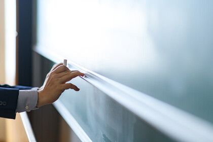 Hand vor einer Tafel