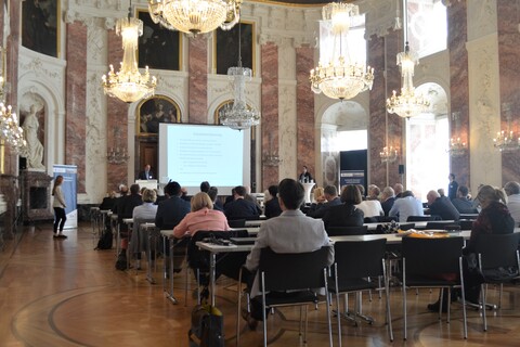 Gefüllte Aula des Schloss Mannheim mit Blick Richtung Redner