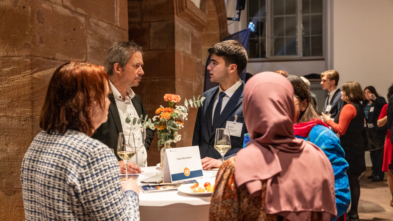 Fünf Personen unterhalten sich an einem Tisch