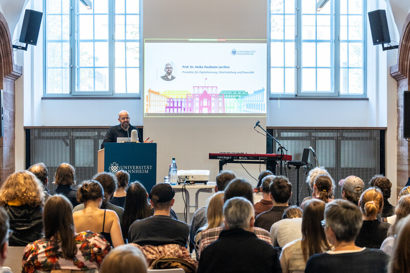 Prof. Heiko Paulheim am Podium spricht in den Katakomben zur Diversity Week. Vor ihm sitzt das Publikum und hört zu. 