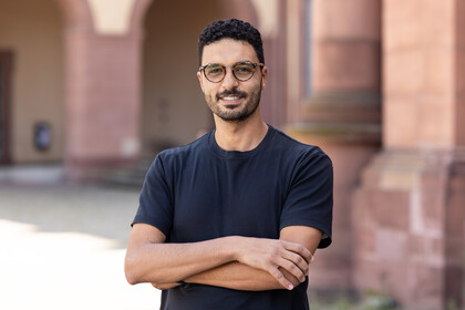 Portraitfoto von Hossam Abdellatif. Er trägt eine Brille und ein dunkelblaues T-Shirt.