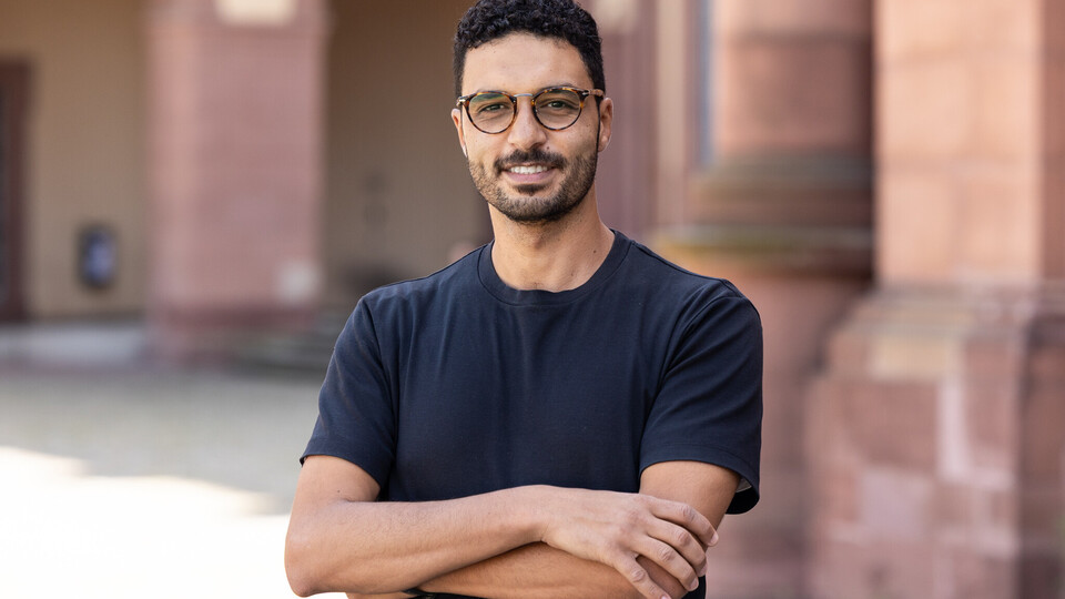 Portraitfoto von Hossam Abdellatif. Er trägt eine Brille und ein dunkelblaues T-Shirt.
