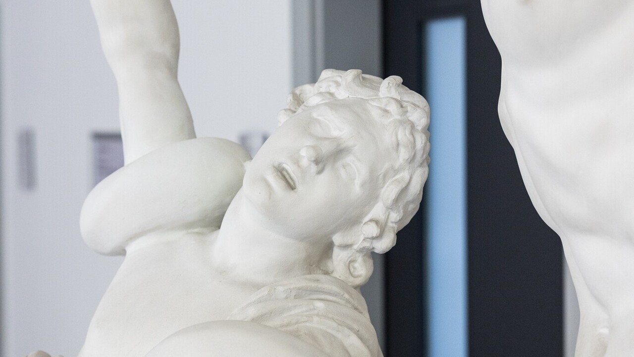 Eine antike Skulptur eines Mannes streckt mit einem schmerzerfüllten Blick seine rechte Hand nach oben. Um seine Schultern schlängelt sich eine Schlange.