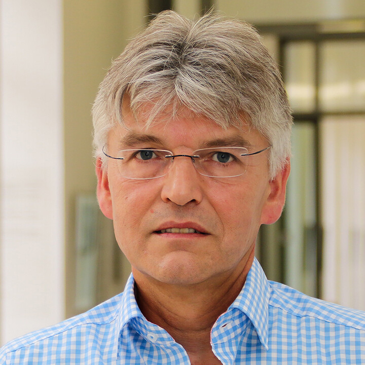 Prof. Dr. Spengel mit grauen Haaren, einer rahmenlosen eckigen Brille und einem blau-weiß kariertem Hemd im Porträt