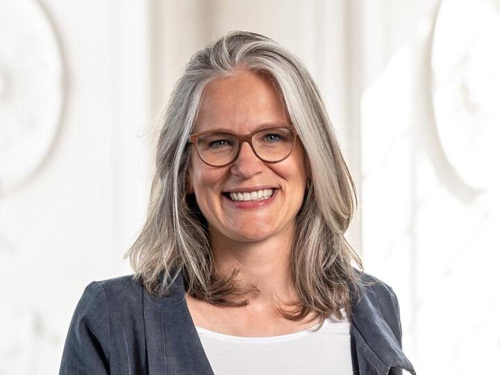 Frau Prof. Jutta Mata hat graue halblange Haare, sie trägt eine braune Brille und einen grauen Blazer.