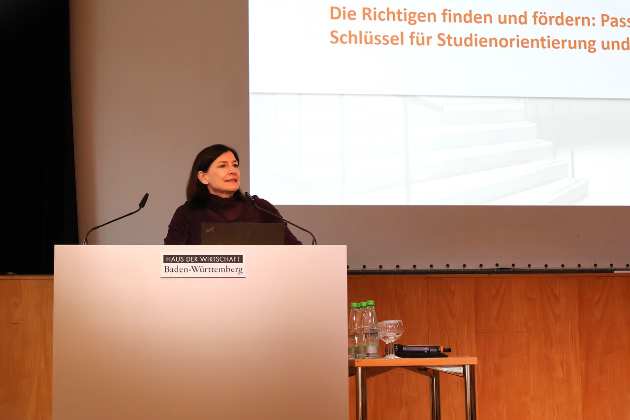 Prof. Dr. Birgit Spinath eröffnet den zweiten Tag und spricht von einem Rednerpult aus.