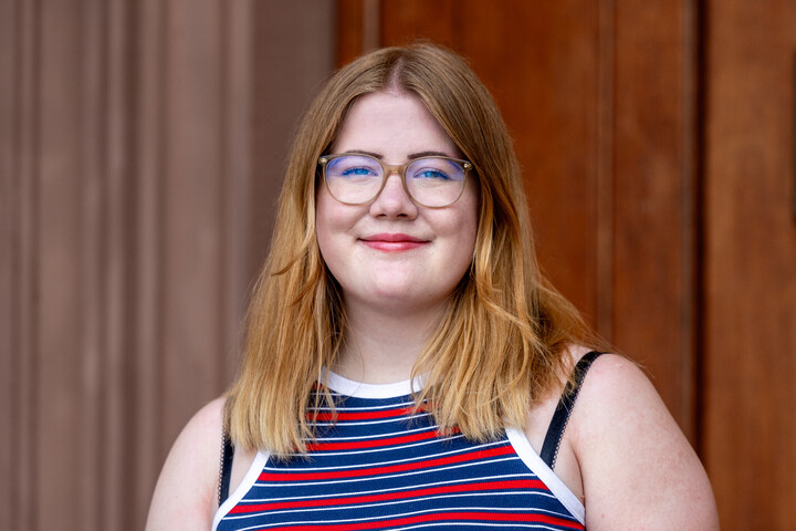 Mila Revink. Sie trägt schulterlange Haare und Brille und lächelt freundlich in die Kamera.