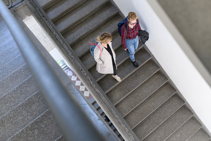 Zwei Studentinnen gehen eine Treppe im Mannheimer Schloss runter.
