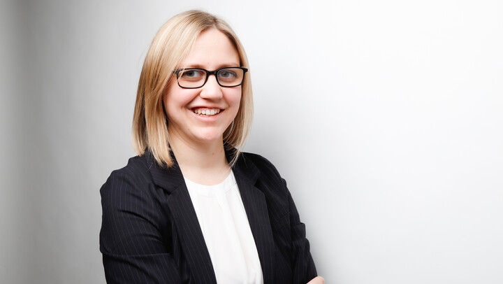 Lara Többen. She is wearing a black jacket over a white shirt in front of a white background.