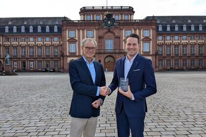 Juniorprofessor des MISES, Gunther Glenk, und der Dekan der Fakultät für Betriebswirtschaftslehre der Universität Mannheim, Joachim Lutz, geben sich vor dem Schloss der Universität Mannheim die Hand.