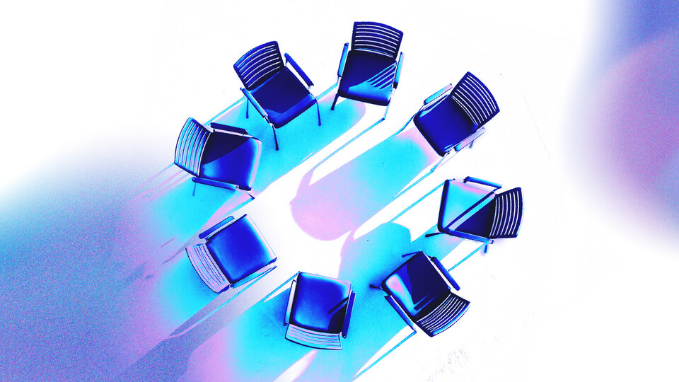 Acht blaue Stühle stehen in einem Kreis.