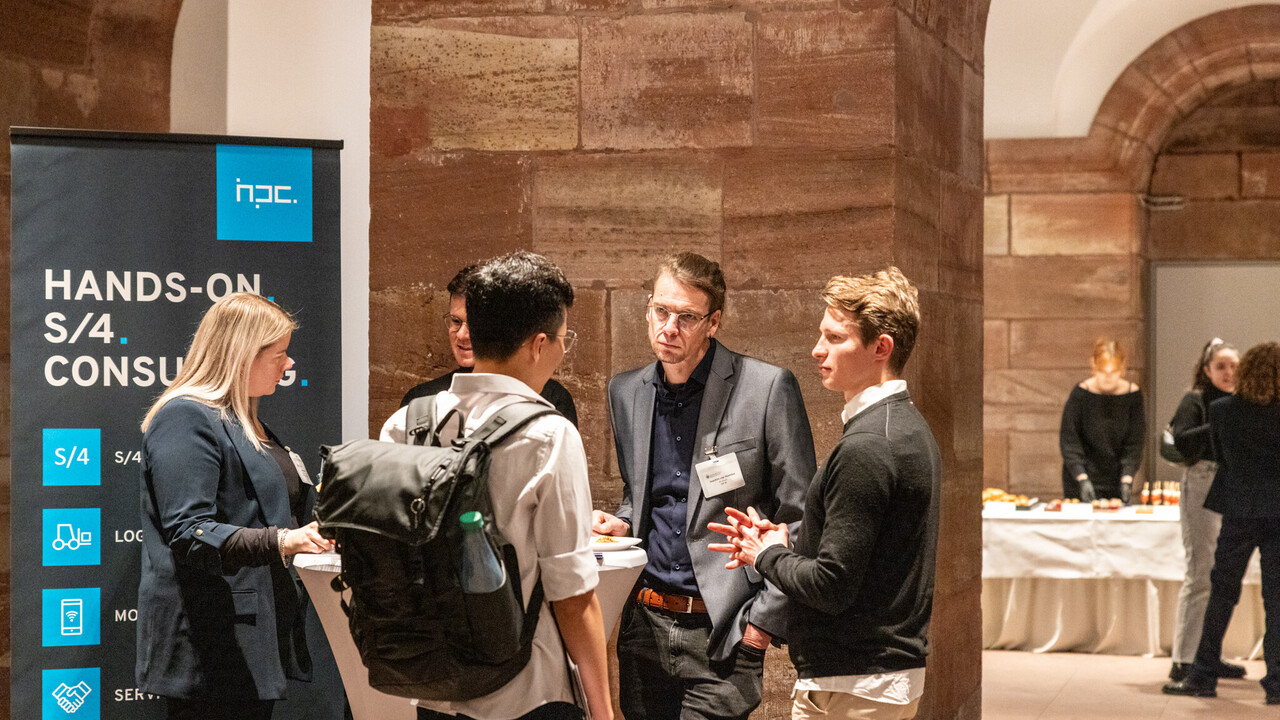 Fünf Menschen unterhalten sich an einem Tisch