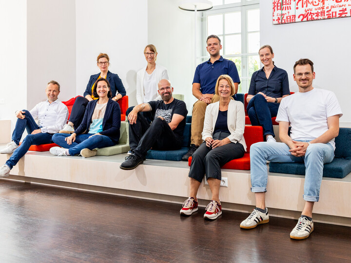 Ein Gruppenfoto der neun Mitglieder des KI-Kernteams. Sie schauen alle lächelnd in die Kamera.