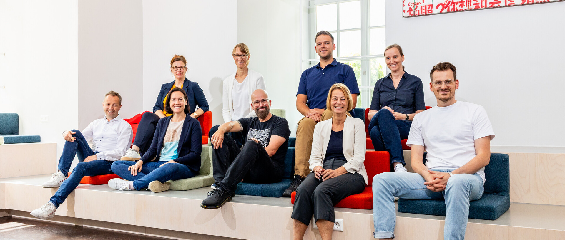 Ein Gruppenfoto der neun Mitglieder des KI-Kernteams. Sie schauen alle lächelnd in die Kamera.