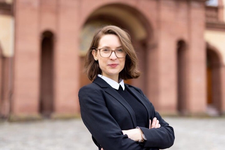Porträtfoto von Prof. Dr. Svenja Behrendt. Sie steht auf dem Ehrenhof und verschränkt die Arme.