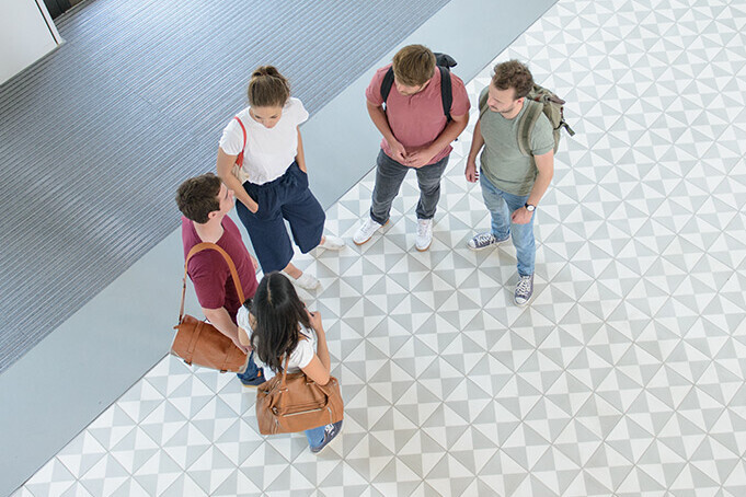 A group of students are talking in the entrance hall of B6, 30-32.