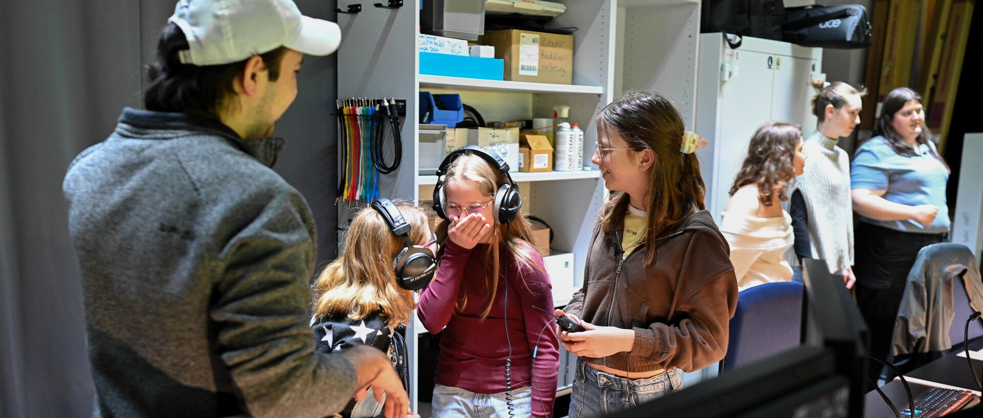 Teilnehmerinnen vom GirlsDay im Videostudio der UNIT mit Kopfhörern auf.