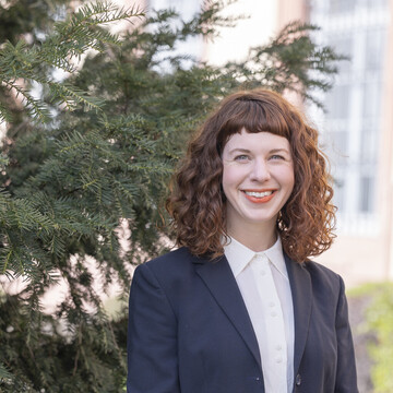 Corinna Kröger. Corinna Kröger lacht freundlich und trägt ein dunkles Jackett.