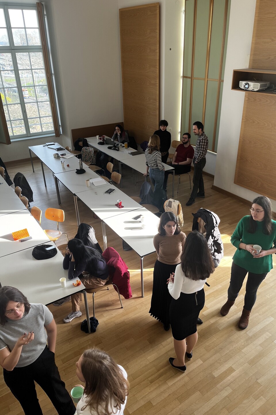 Gruppen von Teilnehmenden unterhalten sich während der Pause im Stehen