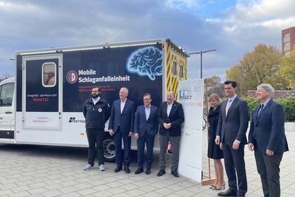 Mitglieder des Institute for Enterprise Systems stehen vor der mobilen Schlagfalleinheit auf dem Ehrenhof der Universität Mannheim