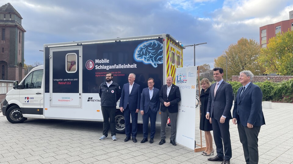 Mitglieder des Institute for Enterprise Systems stehen vor der mobilen Schlagfalleinheit auf dem Ehrenhof der Universität Mannheim