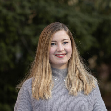  Christine Bickert. Sie trägt einen grauen Rollkragenpullover und lächelt freundlich.