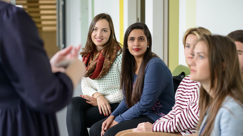 Mehrere Frauen hören einer sprechenden Person aufmerksam zu.