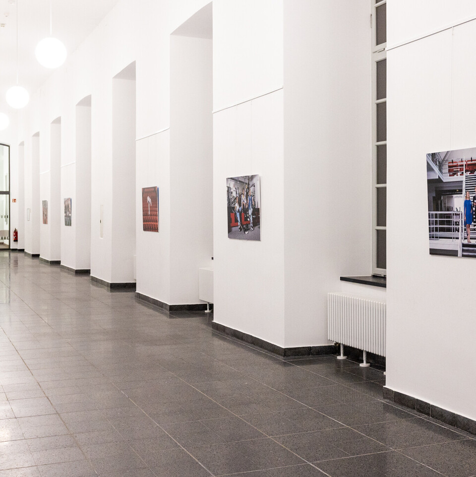 In einem Flur hängen Bilder an der Wand.