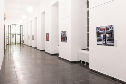 In einem Flur hängen Bilder an der Wand.