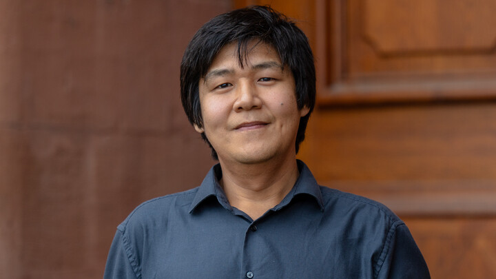 Porträtbild von Prof. Nan Zhang, Ph.D., vor einer braunen Holztür