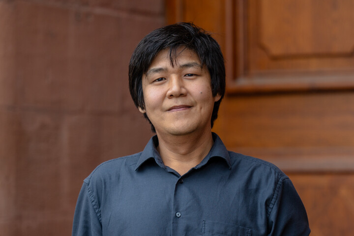 Porträtbild von Prof. Nan Zhang, Ph.D., vor einer braunen Holztür