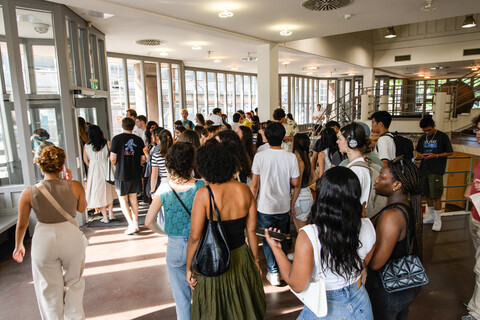 Viele Studierende laufen durch das Foyer des A3-Gebäudes. Im Hintergrund große Fenster.