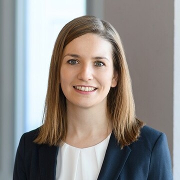 Portrait of Janina Heker. She is wearing a dark blazer and a white blouse.