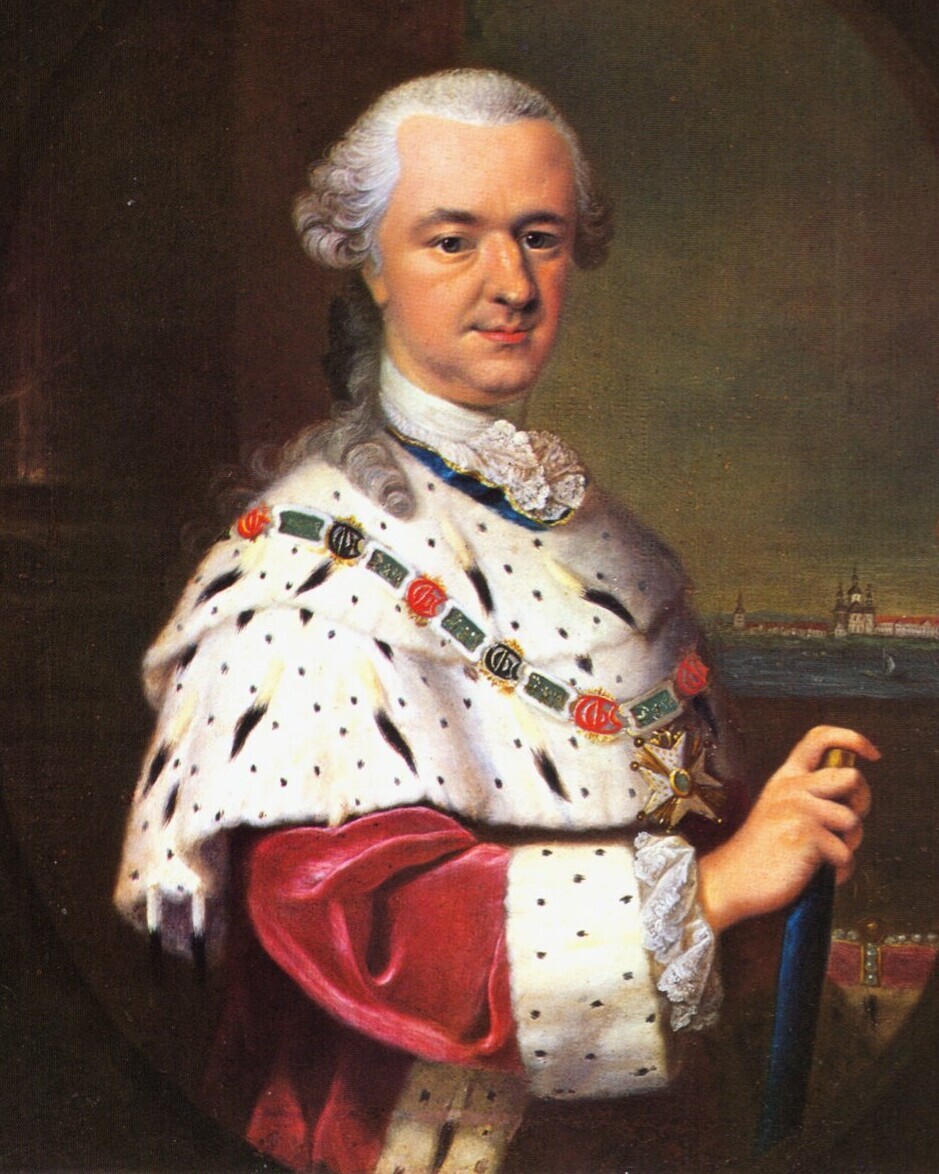 Kurfürst Karl Theodor in rotem Samtgewand mit weißem Hermelinmantel und Ordenskette, hält einen Stab, Hintergrund mit Stadt und Fluss