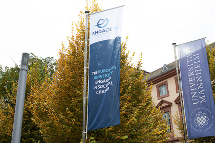 Die Fahnen von Engage.Eu sowie der Uni Mannheim stehen nebeneinander vor dem Schloss der Uni.