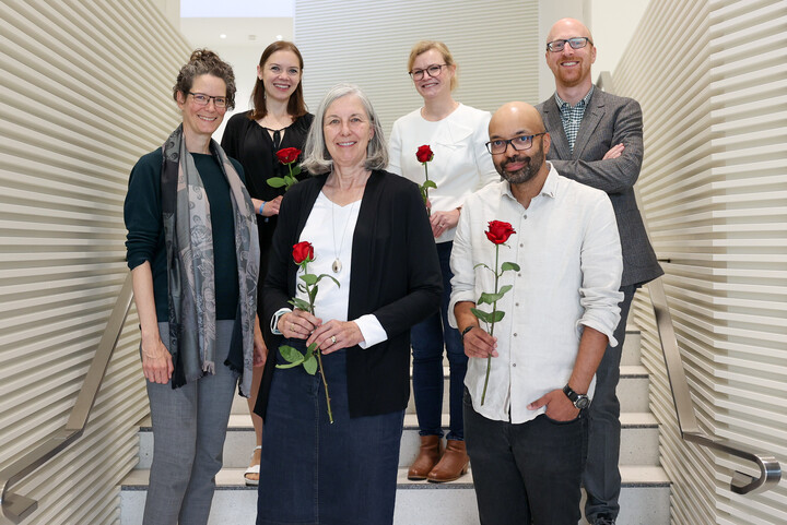 4 Frauen und 2 Männer stehen in formeller Kleidung auf einer Treppe. Die vier Absolvent:innen des IPSDS Programms halten rote Rosen in den händen. Prof. Dr. Frauke Kreuter und Prof. Dr. Florian Keusch stehen an ihrer Seite. 