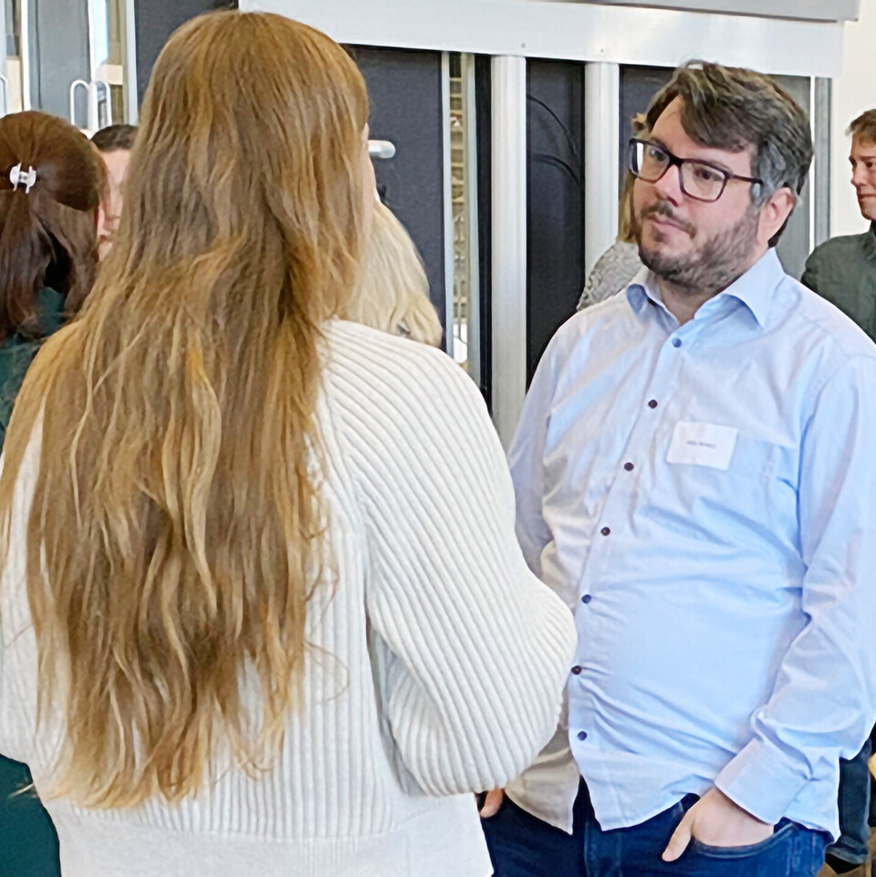 Teilnehmende der InnoMA-Abschlussveranstaltung unterhalten sich miteinander.