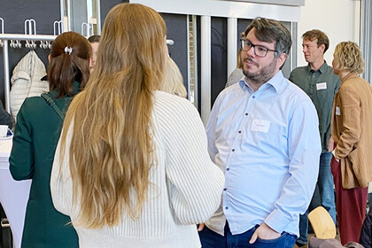 Teilnehmende der InnoMA-Abschlussveranstaltung unterhalten sich miteinander.