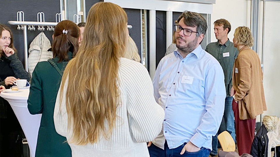 Teilnehmende der InnoMA-Abschlussveranstaltung unterhalten sich miteinander.