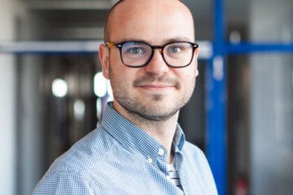 Martin Schnuerch hat kurze braune Haare. Er trägt eine dunkle Brille, einen Dreitagesbart und ein hellblaues Hemd.