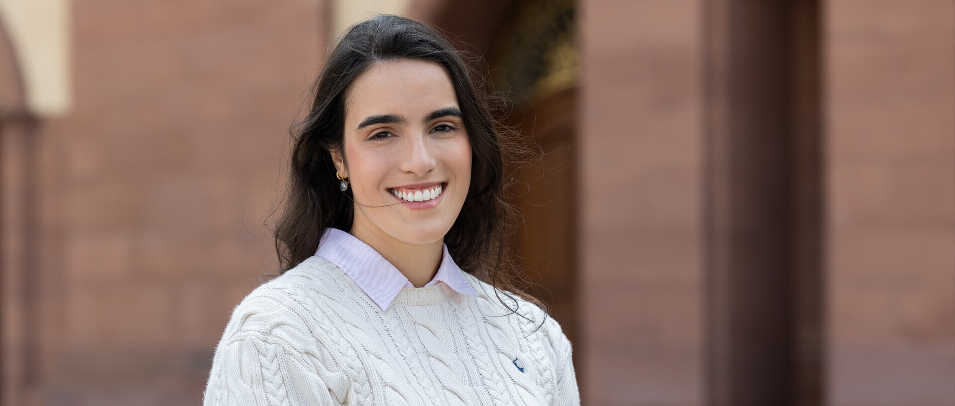 Beatriz Rodriguez trägt einen weißen Pullover und lächelt.