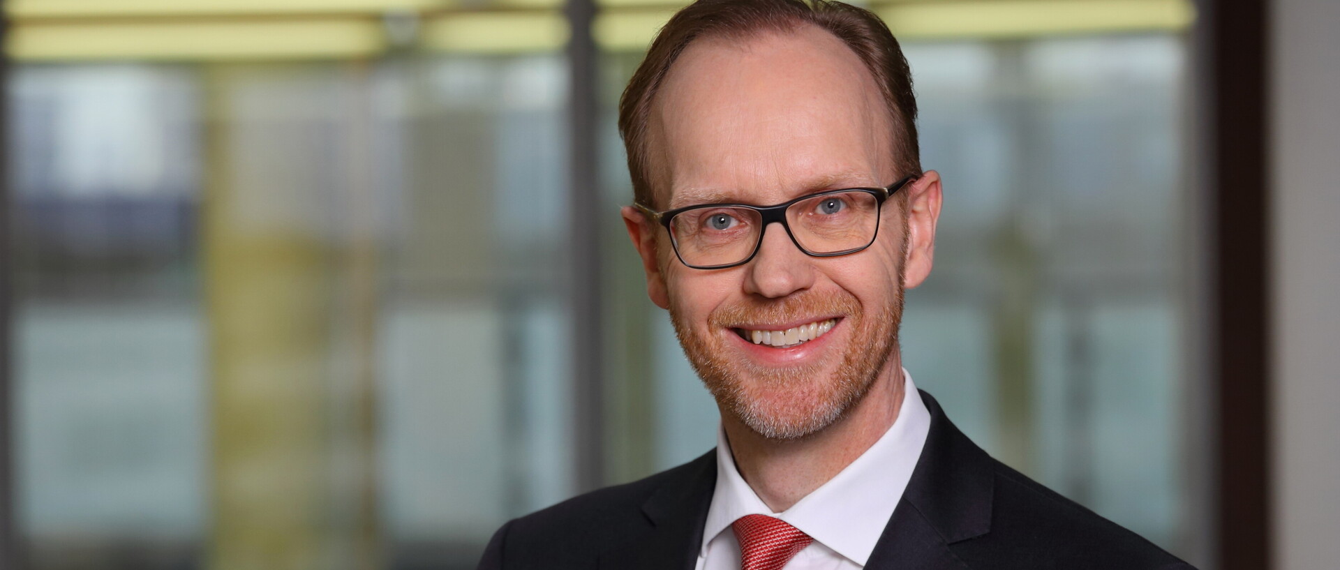Portraitfoto eines Mannes im Anzug. 