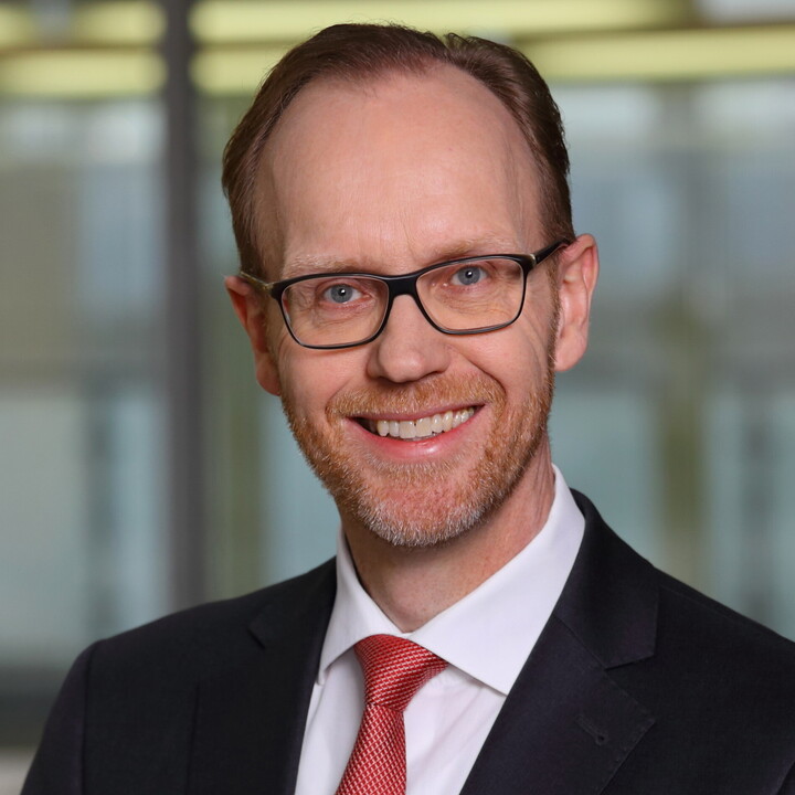 Portraitfoto eines Mannes im Anzug.