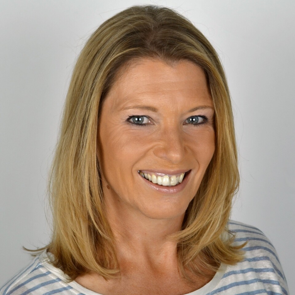 Porträt von Christiane Koch. Sie hat halblange blonde Haare, trägt ein gestreiftes Shirt und lächelt in die Kamera.