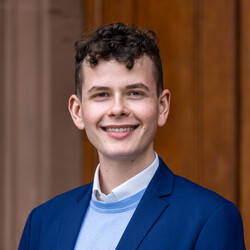 Felix Haas. Die Person trägt einen blauen Sakko.