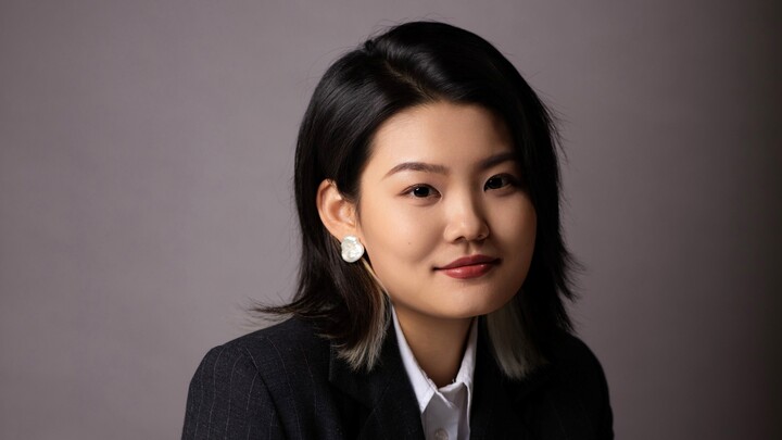 Yue Wu wearing a white blouse and black blazer.