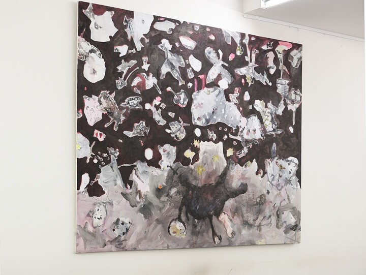 Die Aufenthaltsfläche im Schneckenhof Ost mit braunen Tischen und einem Bild an der Wand, das zahlreiche kleine und mittelgroße Wesen und Gegenstände zeigt  