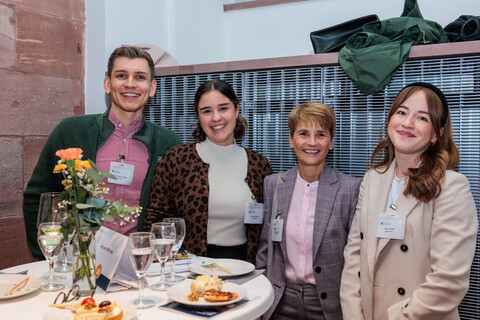 Vier Personen stehen nebeneinander und posieren für ein Foto.