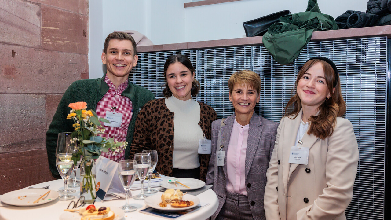 Vier Personen stehen nebeneinander und posieren für ein Foto.