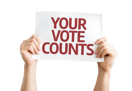 zwei Hände halten ein Schild, auf dem steht your vote counts